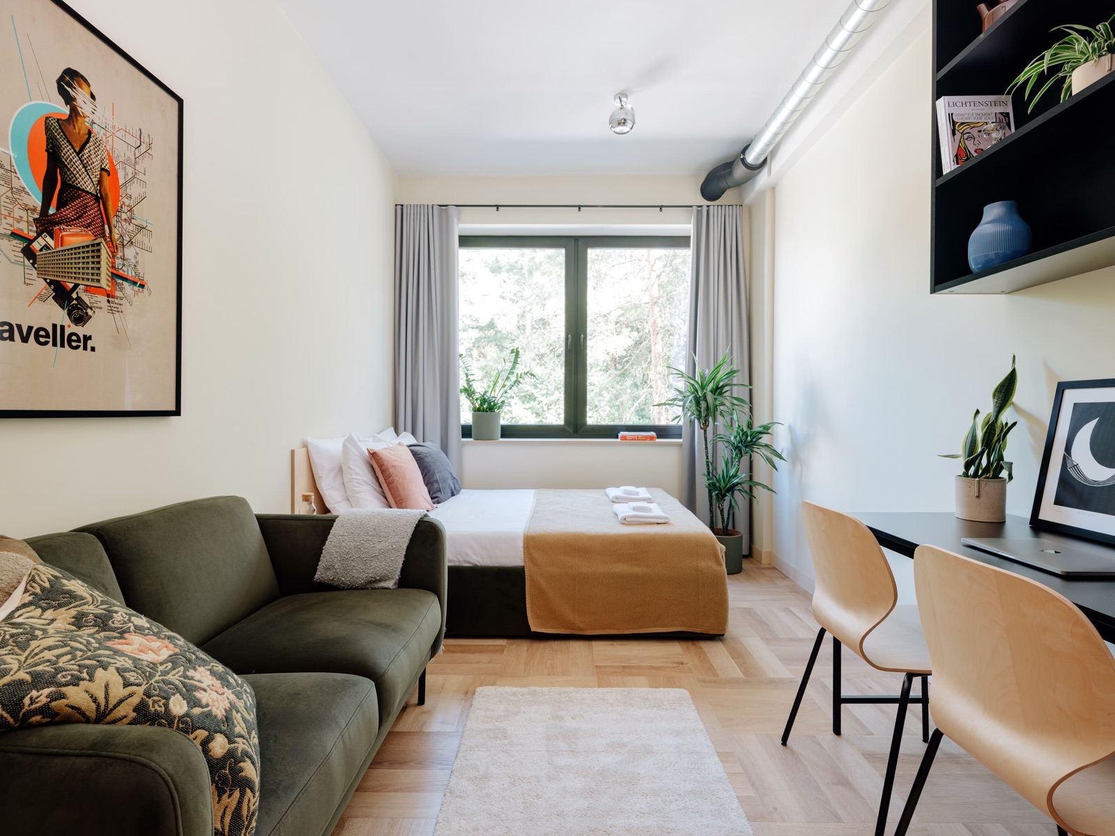 A furnished Stereo House studio with a bed, desk and kitchenette